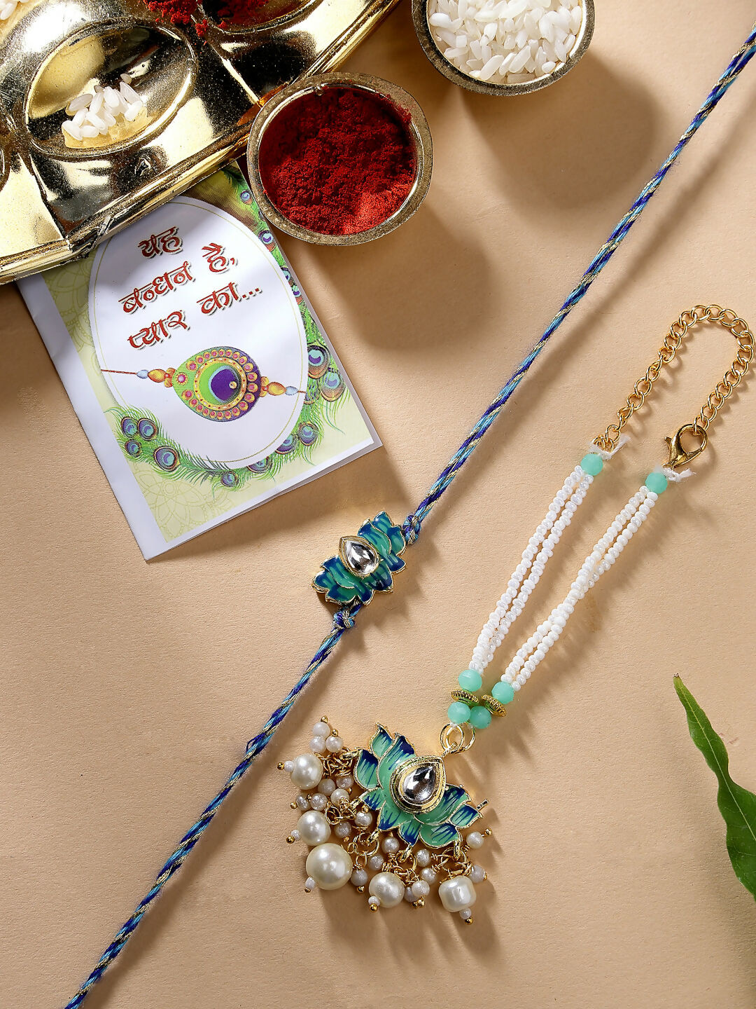 NVR Women & Men Set of 2 Turquoise Blue Lotus Shape Kundan-Studded & Beaded Handcrafted Wraparound Rakhi Set With Roli Chawal