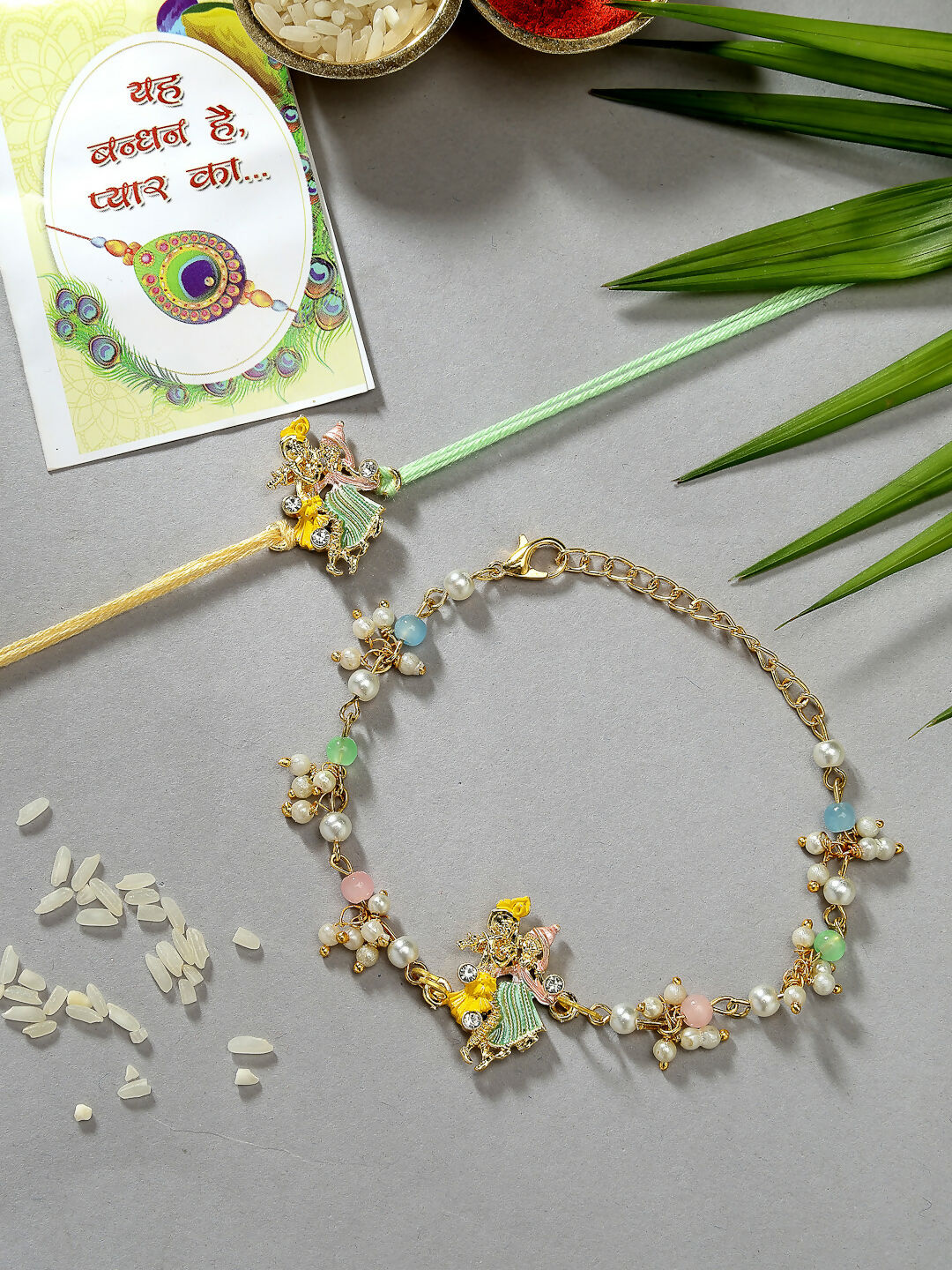 NVR Women & Men Set of 2 Multicolor Gold-Toned Radha Krishna Beaded Bhaiya Bhabhi Rakhi With Roli Chawal & Chocolate