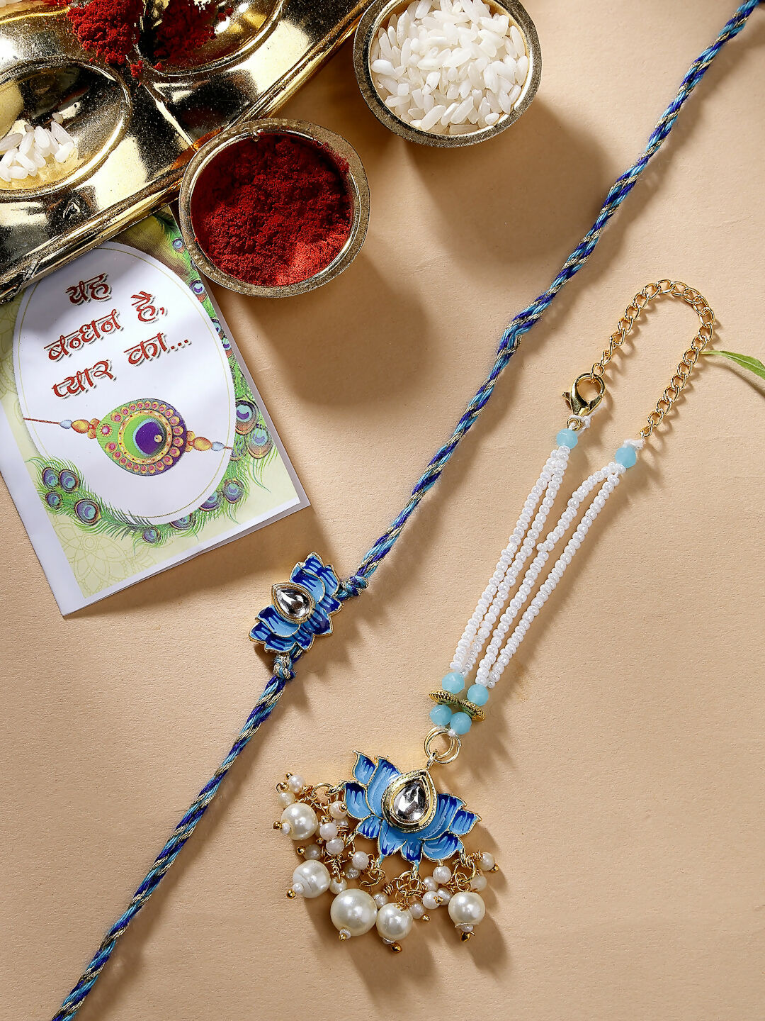 NVR Women & Men Set of 2 Blue Lotus Shape Kundan-Studded & Beaded Handcrafted Wraparound Rakhi Set With Roli Chawal